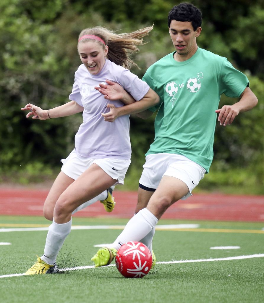 Edmonds-Woodway&rsquo;s Gabby Clark (left) and Cameron Cohn vie for control of the ball during a charity match to raise money for the Special Olympics on Friday night at Edmonds Stadium.