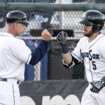 The AquaSox&rsquo;s Gus Craig rounds third and fist bumps manager Rob Mummau (left) after a two-run home run against the Everett Merchants in the 13th annual Everett Cup on Wednesday at Everett Memorial Stadium.