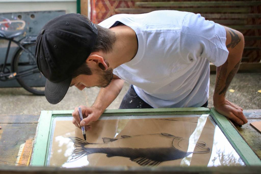 Kevin Clark / The Herald                                Artist Evan Peterson paints on reclaimed glass windows in reverse, creating the foreground first and then thebackground. Peterson is this year&rsquo;s poster artist at the Fresh Paint: Festival of Artists at Work.