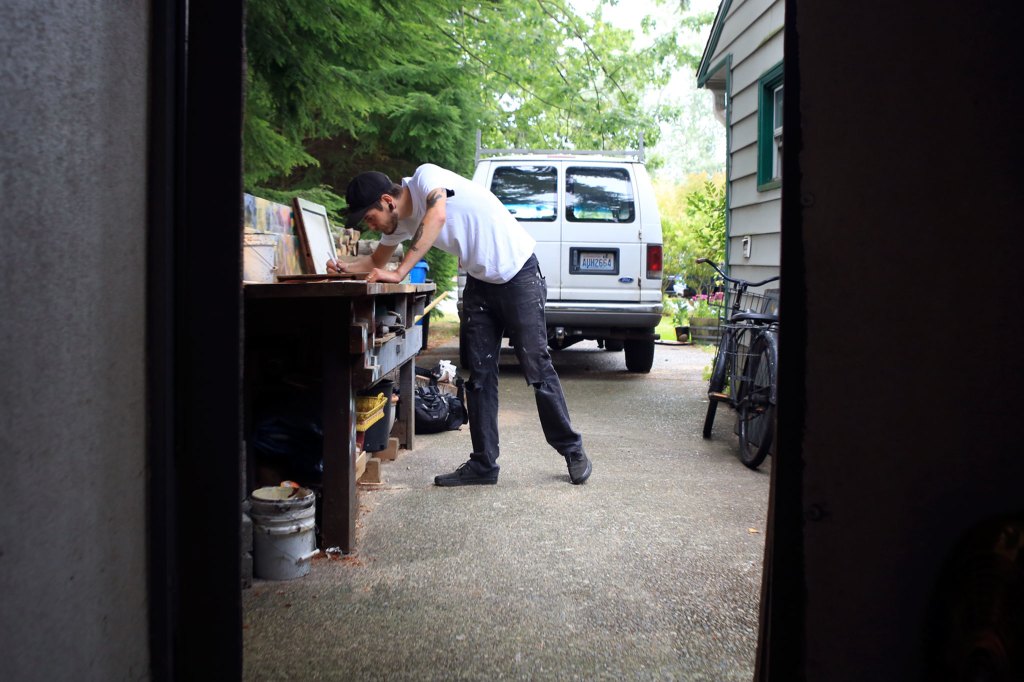Kevin Clark / The Herald                                Artist Evan Peterson paints on reclaimed glass windows in reverse, creating the foreground first and then thebackground. Peterson is this year&rsquo;s poster artist at the Fresh Paint: Festival of Artists at Work.