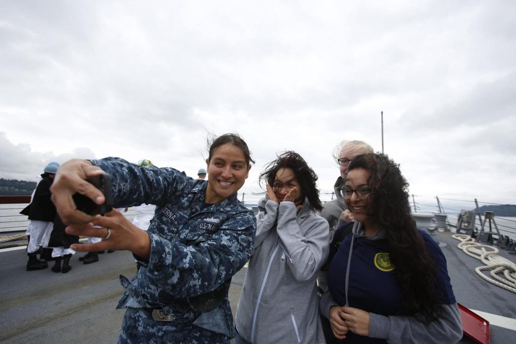 Petty Officer 2nd Class Veronica Cerna (left) takes a selfie with visitors Bella Rakyscova, Sheeara Reynolds and Cynthia Perez as the USS Gridley, the newest guided missile destroyer to be based at Naval Station Everett, sails to Seattle for Seafair on Tuesday. (Andy Bronson / The Herald)