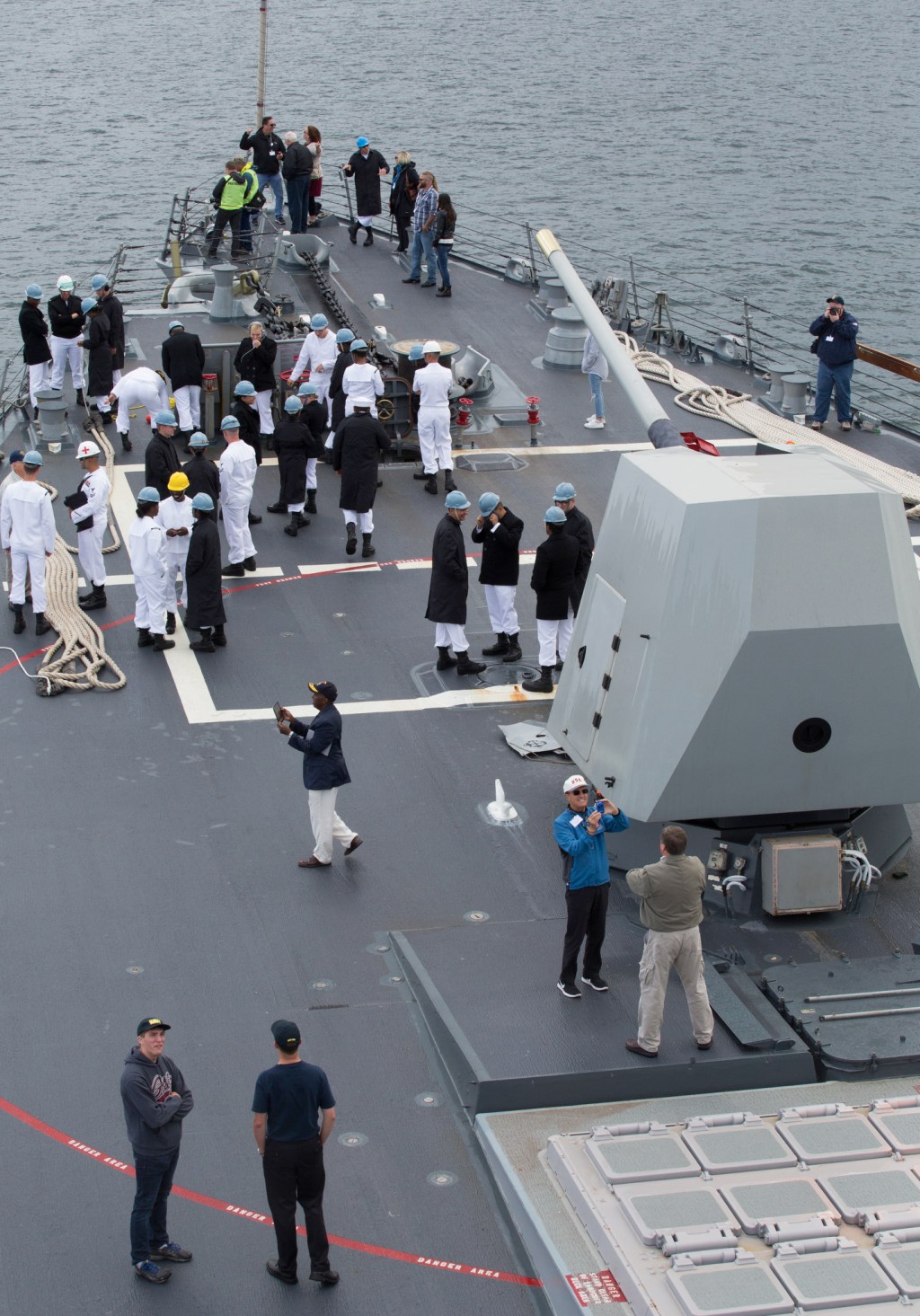 Sailors and visitors mingle and take photos as the USS Gridley, the newest guided missile destroyer based at Naval Station Everett, sails to Seattle for Seafair on Tuesday. (Andy Bronson / The Herald)