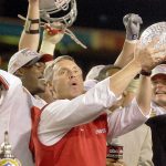 Ohio State football coach Jim Tressel holds up the championship trophy after Ohio State beat Miami 31-24 in two overtimes in the 2003 Fiesta Bowl in Tempe, Arizona, to claim the national championship. (AP Photo/Paul Sakuma)