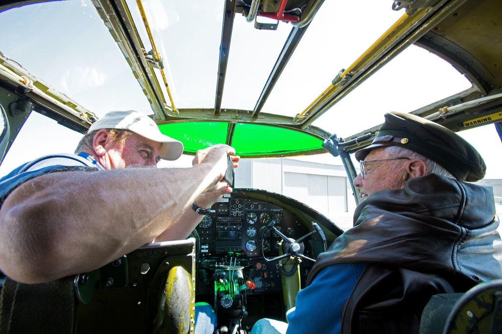 Pilot John Magoffin (left) takes a photo of Bob Drew, a former World War II pilot, after they flew in Maid in the Shade, a B-25 Mitchell bomber that flew 15 combat missions during the war, on Monday in Everett. Drew flew the B-25 when not piloting various WWII fighter aircraft. ( Andy Bronson / The Herald )