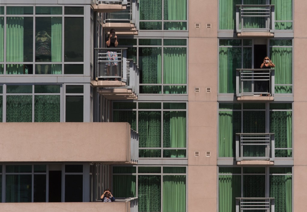 Hotel guests take photos as the USS Gridley, based at Naval Station Everett, docks in Seattle for Seafair on Tuesday. (Andy Bronson / The Herald)