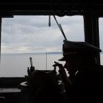 Ensign Tanner Roach takes a bearing from the bridge of the USS Gridley, the newest guided missile destroyer to be based at Naval Station Everett, as it begins heading toward Seattle for Seafair on Tuesday. (Andy Bronson / The Herald)