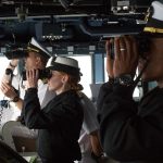 Commander Marc Crawford, Ensign Kaitlyn South and Lt. j.g. Tyrone Frazier peer out through binoculars as the USS Gridley, the newest guided missile destroyer to be based at Naval Station Everett, nears Seattle for Seafair on Tuesday. (Andy Bronson / The Herald)