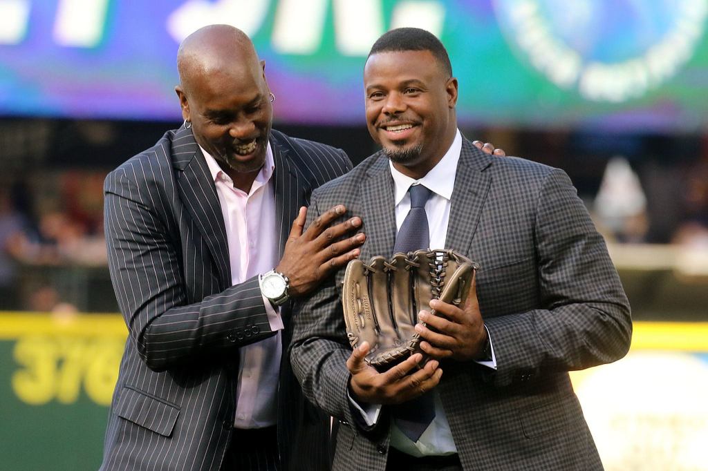 Former Seattle SuperSonic Gary &lsquo;The Glove&rsquo; Payton (left) presents Ken Griffey Jr. with a bronze glove during Griffey&rsquo;s number retirement ceremony Saturday at Safeco Field. (Kevin Clark / The Herald)