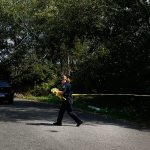 A police officer cordones off 64th Place West in the Chennault Beach area of Mukilteo on July 30 after shootings at a home there left three dead and one injured. (Ian Terry / The Herald)