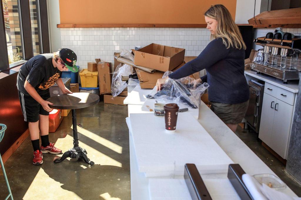 Soren Schreffler, left, and Rachel Schreffler work to assemble a table at Choux Choux Bakery. A federal court is considering a plan to complete the commercial space at Potala Place, a 220-unit apartment building in downtown Everett. (Kevin Clark / The Herald)