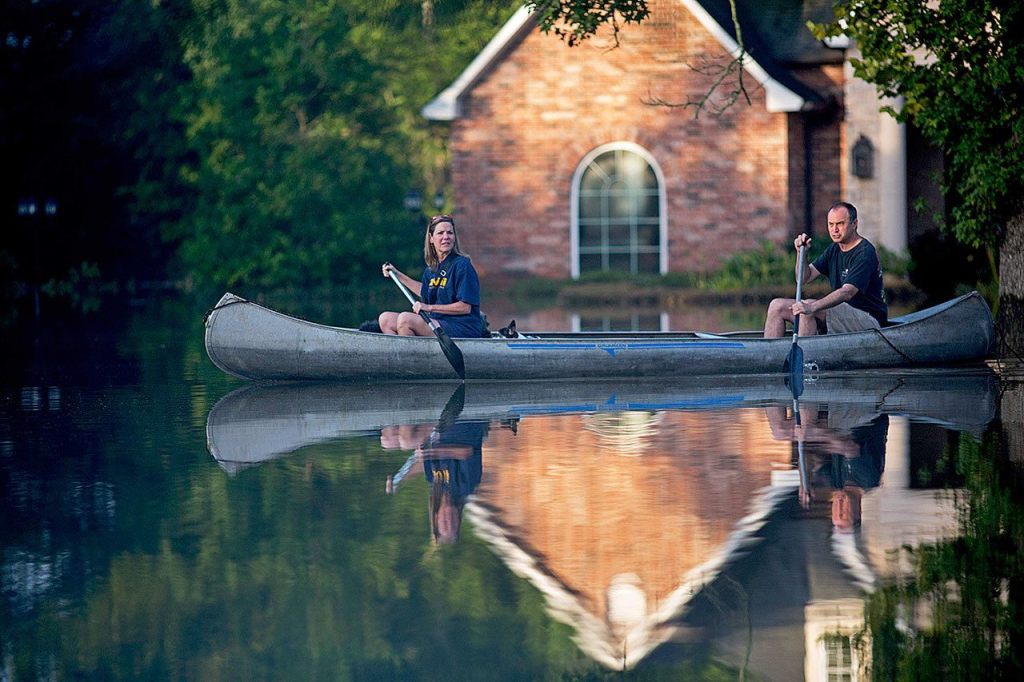 Danny and Alys Messenger canoe away from their flooded home after reviewing the damage in Prairieville, Louisiana, on Tuesday. As waters begin to recede in parts of Louisiana, some residents struggled to return to flood-damaged homes on foot, in cars and by boat. (AP Photo/Max Becherer)