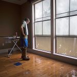 David Key looks at water out of his master bedroom windows in his flooded home in Prairieville, Louisiana, on Tuesday. Key, an insurance adjuster, fled his home as the flood water was rising with his wife and three children and returned today to assess the damage. (AP Photo/Max Becherer)
