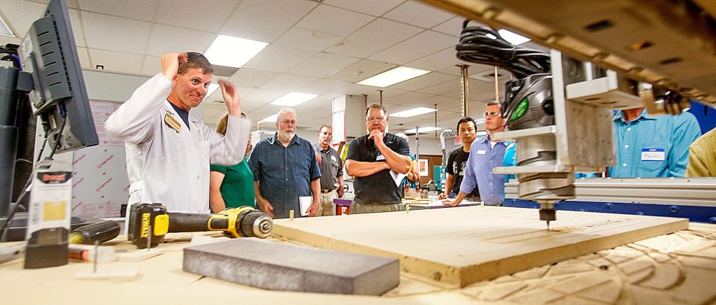 Lab tech Andrew Smolen (left) demonstrates a CNC router driven by 3D software at the Rapid Proto Lab at EdmondsCommunity College. (Dan Bates/The Herald)