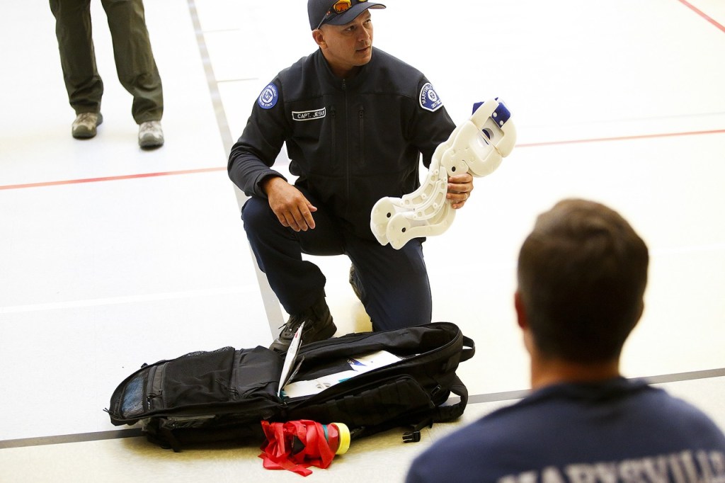 Marysville Fire Department Capt. Rick Jesus goes over tools and equipment carried in an EMT pack for mass casualty situations during a training session at Grove Elementary School in Marysville on Aug. 9. The packs weigh about 25 pounds, are worn by each paramedic and hold only the essentials needed to prevent blood loss and keep a patient breathing. (Ian Terry / The Herald)