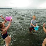 Eric Magelsen lets loose with a bucket of water on his cousin, Rachel Magelsen (left) during a visit to Jetty Island. The ferry to the island runs through Sept. 5. (Herald 2012 file photo)