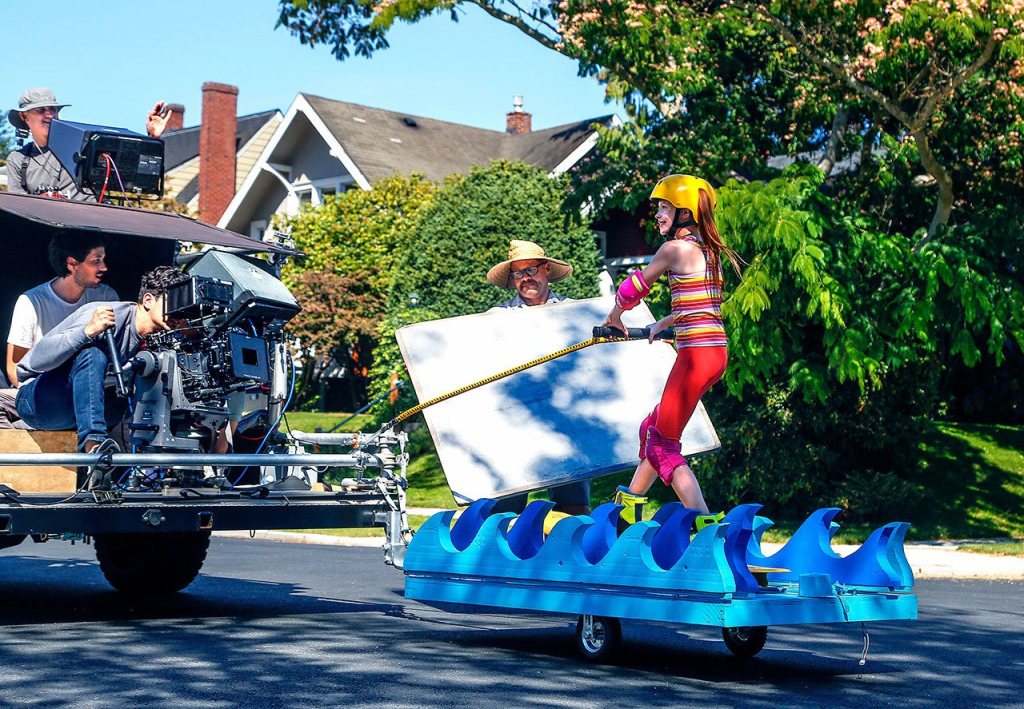 A young actess is filmed cruising north on Rucker Avenue and 14th Street on Wednesday afternoon, as part of a commercial for Fruity Pebbles cereal. (Dan Bates/The Herald)