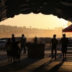 As the sun sets, attendants to the Evergreen State Fair make their way out into the parking lot on Friday evening. (Ian Terry / The Herald)