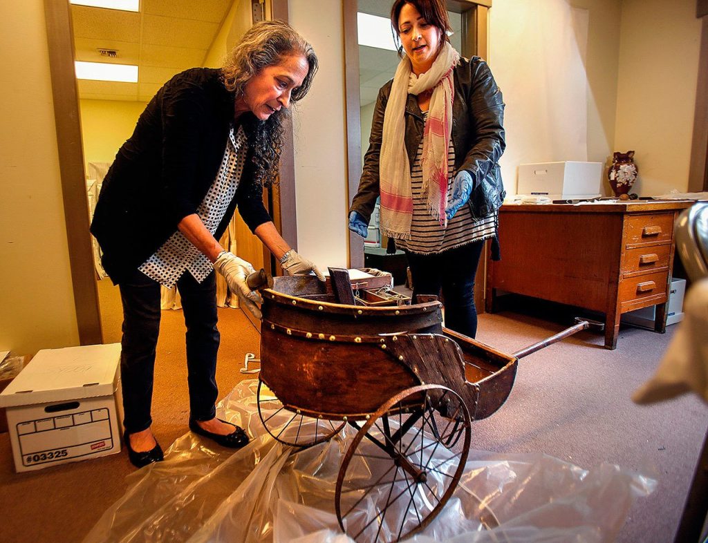 Kim David (left) and Amalia Kozloff put some large sections together on a turn-of-the-century kids cart. (Dan Bates / The Herald)