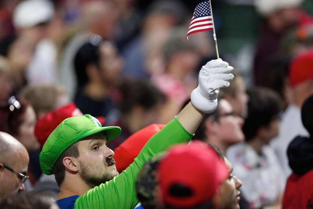 A man dressed as Luigi from the Mario Bros. video game waves a flag before Donald Trump speaks to supporters at Xfinity Arena on Tuesday in Everett. (Andy Bronson / The Herald)