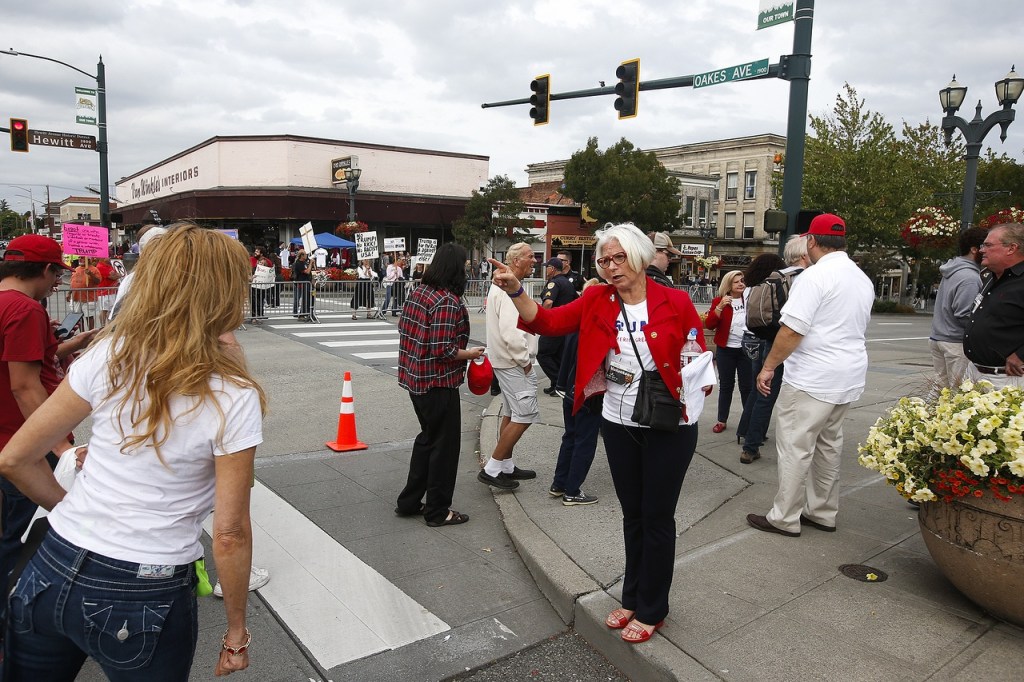 Debbie Blodgett (right), president of the Snohomish County Republican Women&rsquo;s Club, helps guide people to the rally for Republican presidential nominee Donald Trump on Tuesday. (Ian Terry / The Herald)