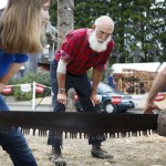 Alvie Marcellus, of Spokane, watches as competitors in a youth lumberjack competition saw a log at the Evergreen State Fair on Tuesday. (Ian Terry / The Herald)