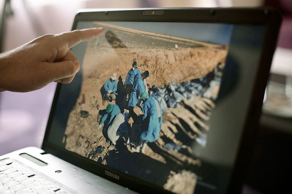 In this May 17 photo, Sirwan Jalal, director of mass graves for the Kurdish Regional Government, points to an image of the site of a mass grave in Irbil, northern Iraq. (AP Photo/Maya Alleruzzo)