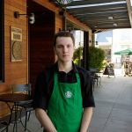Starbucks barista Oliver Savage poses for a photo in front of a Starbucks store near where he works, Monday in Seattle. Savage is joining other workers and city leaders in pushing for new &ldquo;secure scheduling&rdquo; rules for retail and food-service businesses with hourly employees, including requiring them to schedule shifts two weeks in advance, and offer hours to existing employees before hiring new staff. (AP Photo/Ted S. Warren)