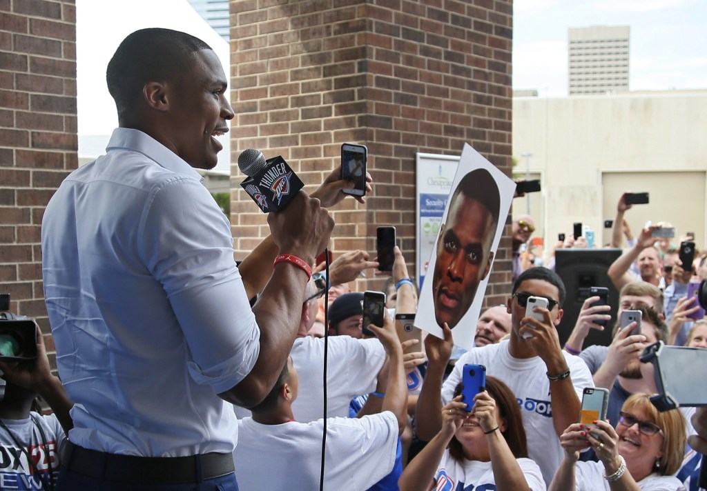 Oklahoma City Thunder guard Russell Westbrook is greets fans as he arrives for a news conference to announce that he has signed a contract extension on Thursday. (AP Photo/Sue Ogrocki)