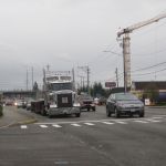 Traffic drives by a seven-story apartment project under construction in Lynnwood. The city is preparing for traffic from more than 1,600 apartments that are expected to open in the next few years.