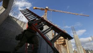 A worker carries a ladder during construction of the seven-story apartment building called CityCenter Apartments on Wednesday, Feb. 10, 2015 in Lynnwood, Wa. Lynnwood is experiencing a jolt of construction with two dozen major projects and more than $1 billion in development under way or soon to be underway.