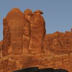 Climbers stand at the top of a spire in National Parks Adventure. The story follows famous climber Conrad Anker, his stepson and their family friend.