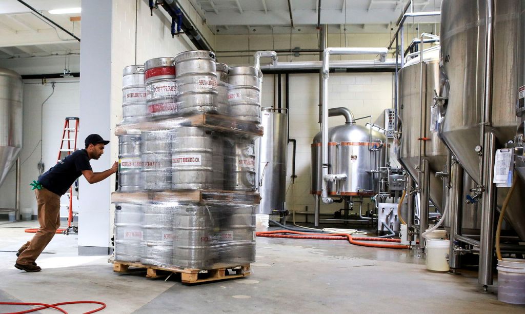 Jarrett Ziemer pushes pallets of empty kegs for unloading at Scuttlebutt Brewery in Everett.