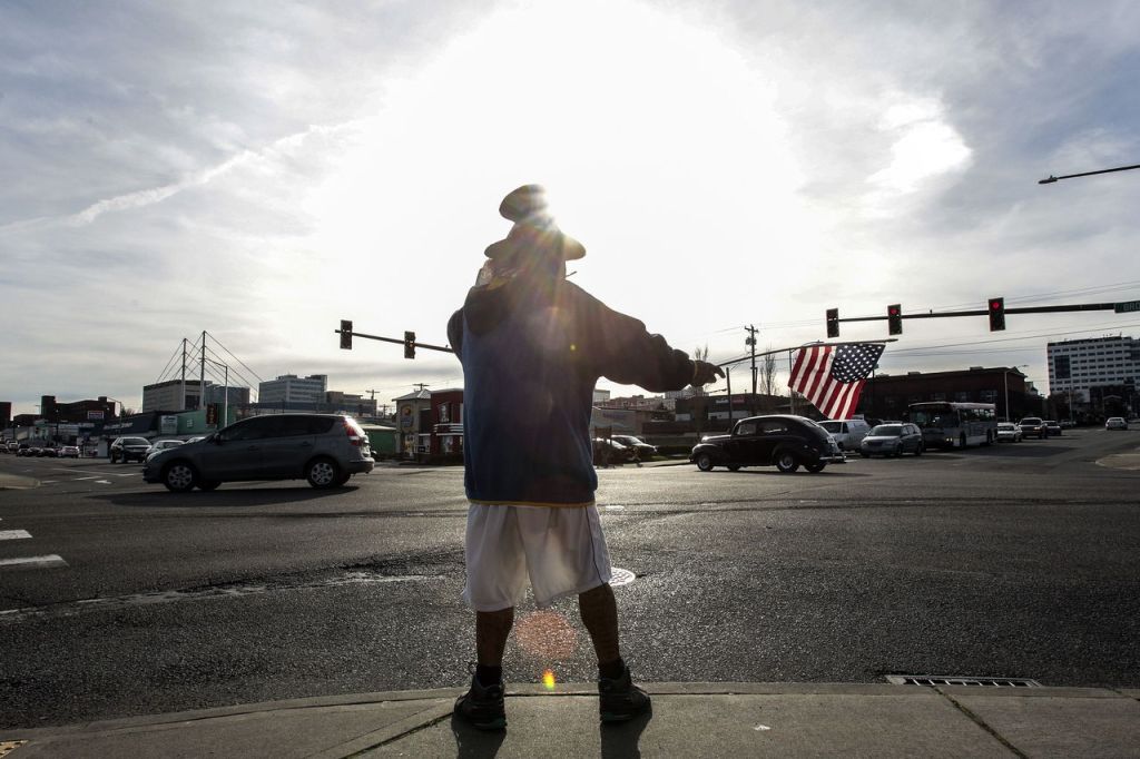 Samiu Bloomfield, 66, waves to passing motorists in Everett.