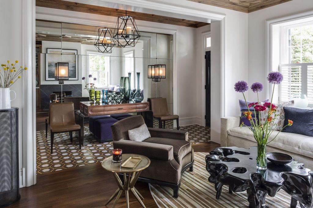 To make this townhome by Patrick Sutton appear more spacious, a mirror was set into the wall and trimmed like an opening into another room. The illusion makes the foyer seem as though it continues through to the other side of the wall.