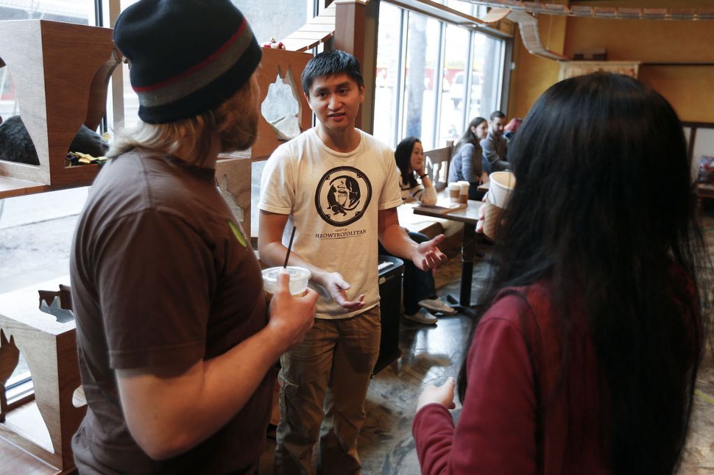 Meowtropolitan Cafe co-founder Matt Lai (center) talks with visitors to the cafe in Seattle in January.