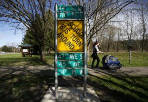 Snohomish resident Laura Stutz walks past used street signs that have been converted into interpretive signs that, on the other side, display tidbits of information about the county&rsquo;s history along the Centennial Trail in Snohomish. The signs are part of a bigger project called Past Forward.