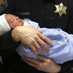Snohomish Sheriff&rsquo;s Deputy Keith Poteet holds a sleeping Case Daniel Bartelheimer at Providence Regional Medical Center Everett on Wednesday. Kyla Bartelheimer and her husband were heading to the hospital when she begin delivering the baby. Poteet arrived to help the delivery while on patrol in Snohomish.
