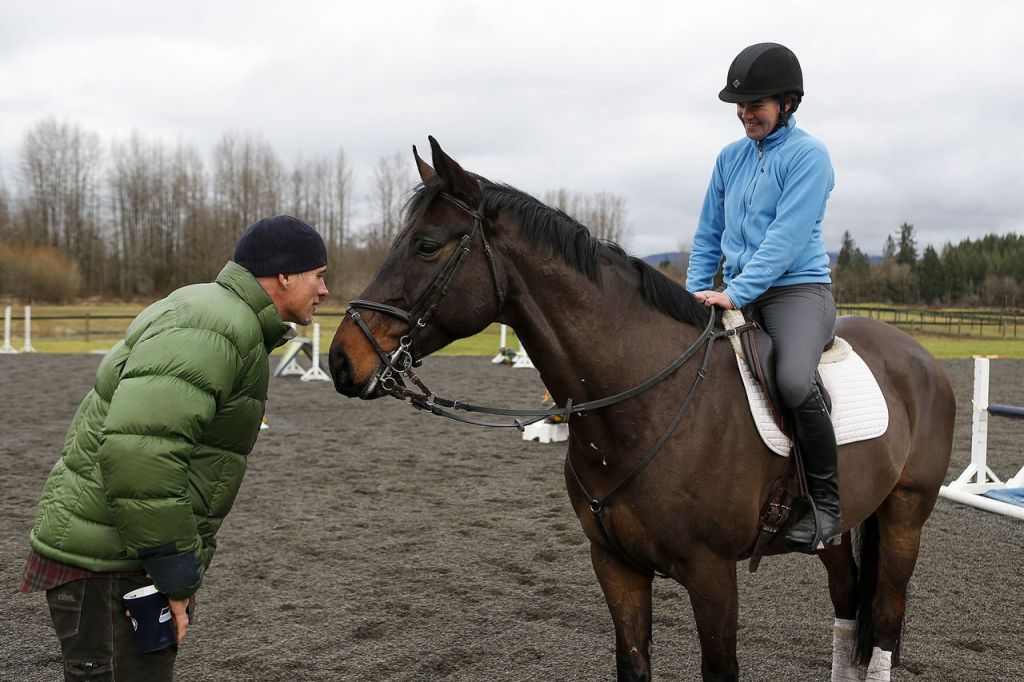 Mark Salser greets Archie, a 7-year-old cross breed, while talking to his wife, Meika Decher at Polestar Farm in Lochsloy on Saturday.