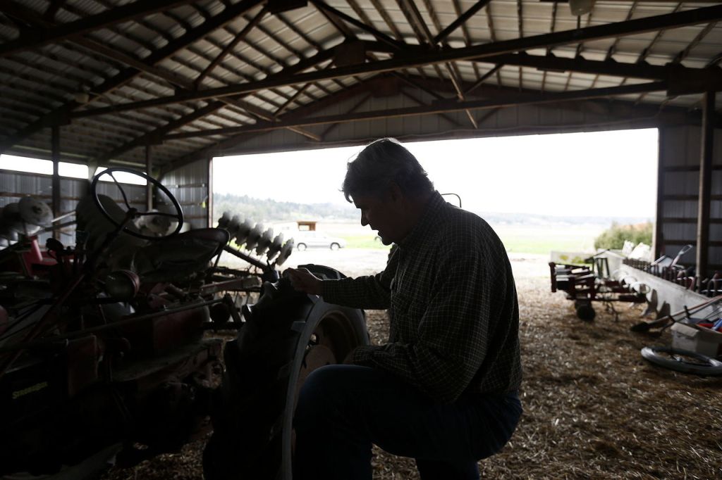 Don Bailey looks over an old tractor that he still uses often on his family&rsquo;s 300-acre farm on Springhetti Road in Snohomish.