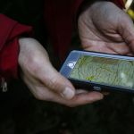 Evergreen Mountain Bike Alliance&rsquo;s Mike Westra looks at a topographical map on his phone of the area along North Mountain Road in Darrington on Thursday. The area is slated to have 20 miles of new mountain bike trails built.