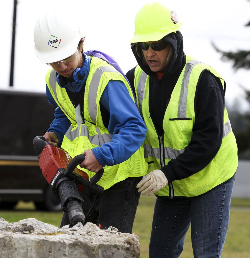 Josh Brown (left), of Marysville, gets help with a breaker from Tawny Sayers on Tuesday during the Snohomish County Trade UP event, which was held on the grounds of Arlington Airport. Sayers is apprenticeship coordinator for the Northwest Laborers-Employers Training Trust.