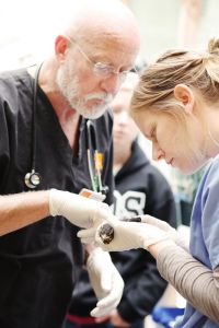 John Huckabee and a student extern do a veterinary check on a PAWS patient.