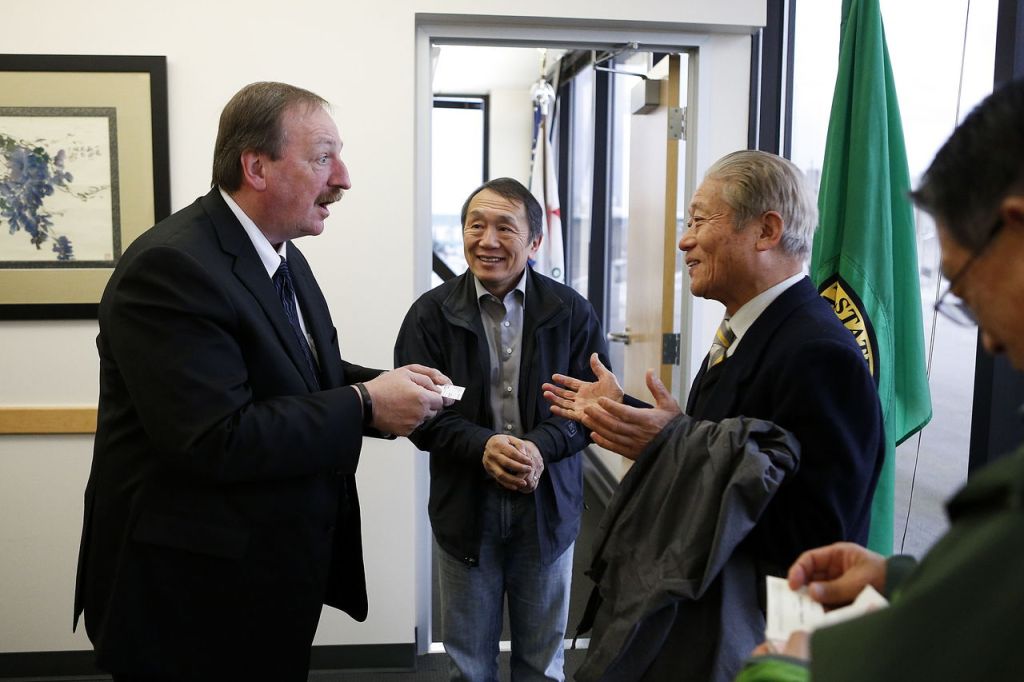 Somers (left) exchanges business cards with members of a Japanese delegation before a meeting with the group Feb. 10 in Everett to discuss the possibility of producing cedar oil from existing mills around the county.