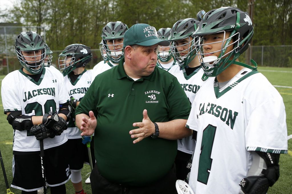 Jackson High School lacrosse coach Craig Hess talks to his players Friday before a game against Shorecrest at Kasch Park in Everett. Hess, a Snohomish County Sheriff&rsquo;s deputy who serves as a school resource officer at Sultan High School, grew up in New York and played lacrosse in college.