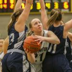 Arlington&rsquo;s Emma Janousek splits Glacier Peak&rsquo;s Abbie Juozapaitis (left) and Charlie Sevenants for the basket and a foul during a 3A District 1 tournament semifinal game Wednesday night at Shorecrest High School in Shoreline. Arlington won 52-45.