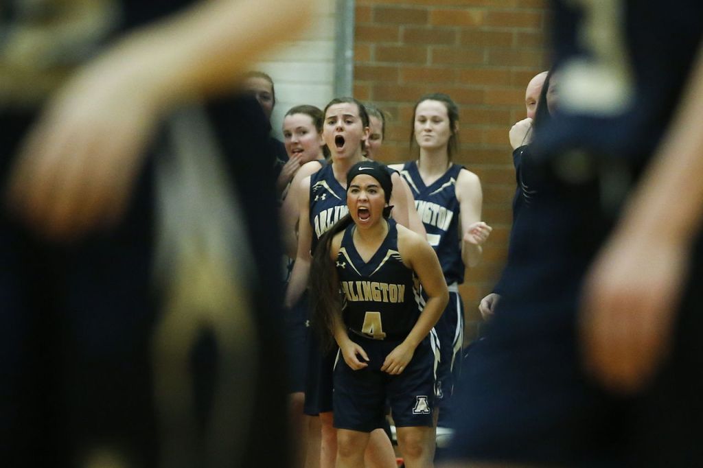 Arlington&rsquo;s Serafina Balderas (center) reacts to a basket with fellow teammates during a 3A state regional game against Bishop Blanchet on Saturday at Mountlake Terrace High School.