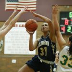 Arlington&rsquo;s Jayla Russ (31) drives through Bishop Blanchet&rsquo;s Lee Erickson (23) and Jillese Bush (33) during a 3A state regional game on Saturday at Mountlake Terrace High School.