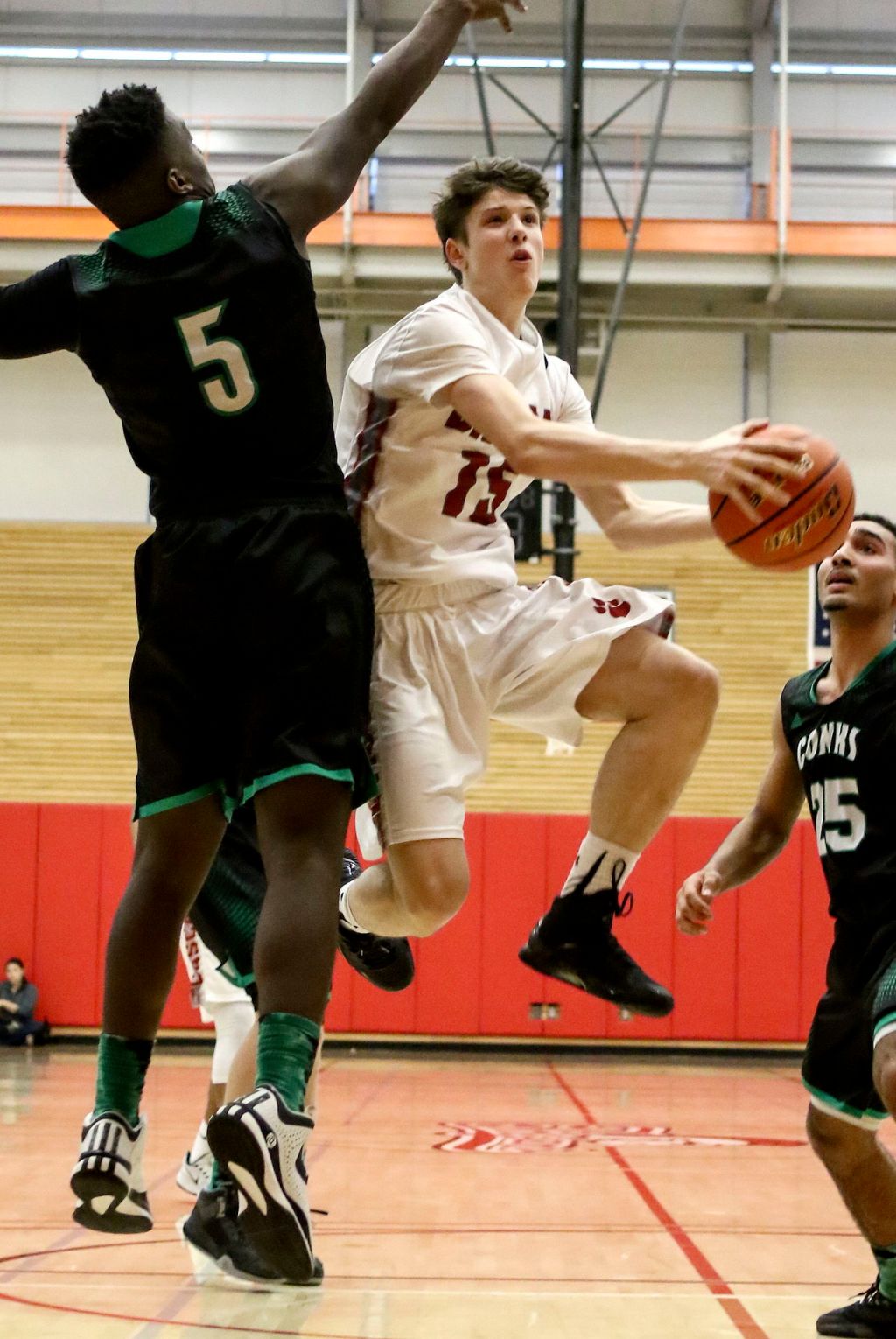 Cascade&rsquo;s Drew Magaoay attempts a shot with Kentwood&rsquo;s Davonte Sanchez defending during a 4A state regional game on Saturday at Everett Community College.