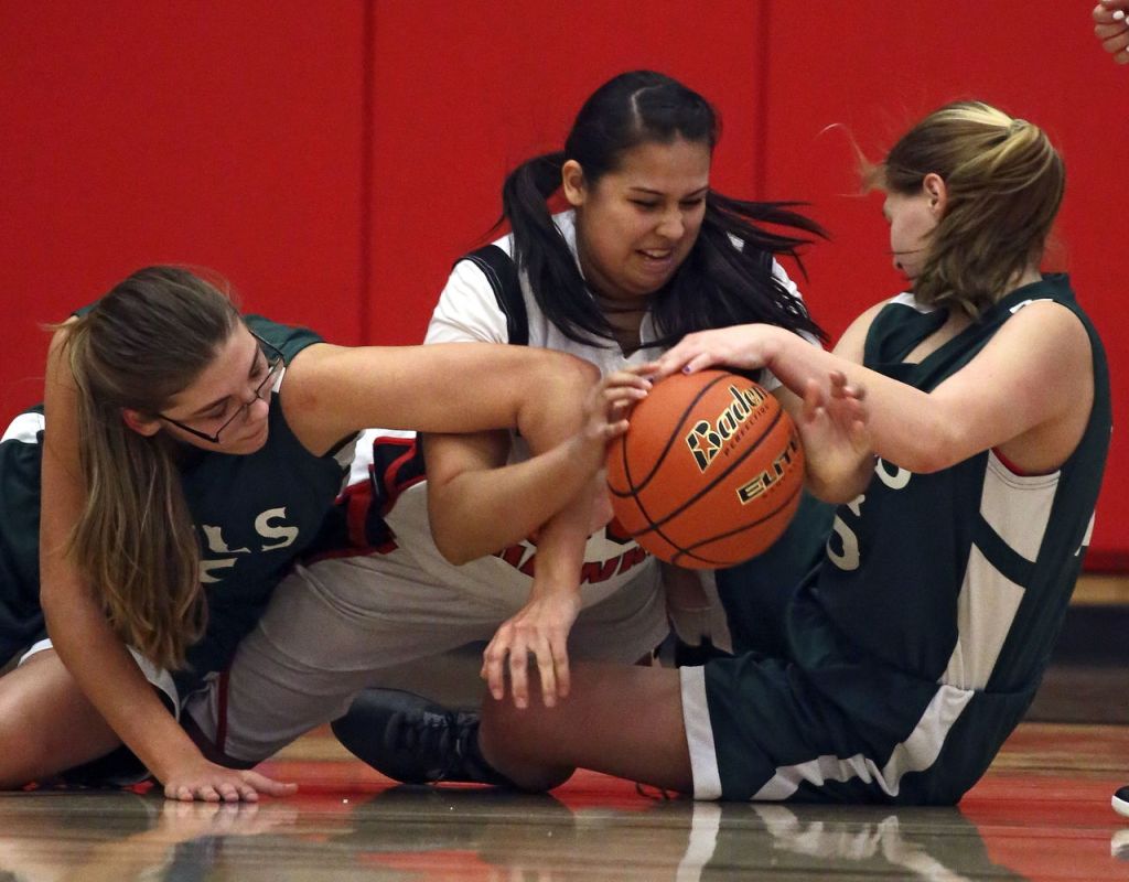 Tulalip Heritage&rsquo;s Desirae Williams (center) struggles for control of a loose ball with Mary M. Knight&rsquo;s Jadyn Davidson (left) and Kaylee Sowle during a 1B state regional game Saturday at Everett Community College. Tulalip Heritage won 54-42.