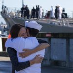 Ashley and Jesse Carpentier hug after the USS Sampson (DDG 102) docks at Naval Station Everett on Monday. (Andy Bronson / The Herald)